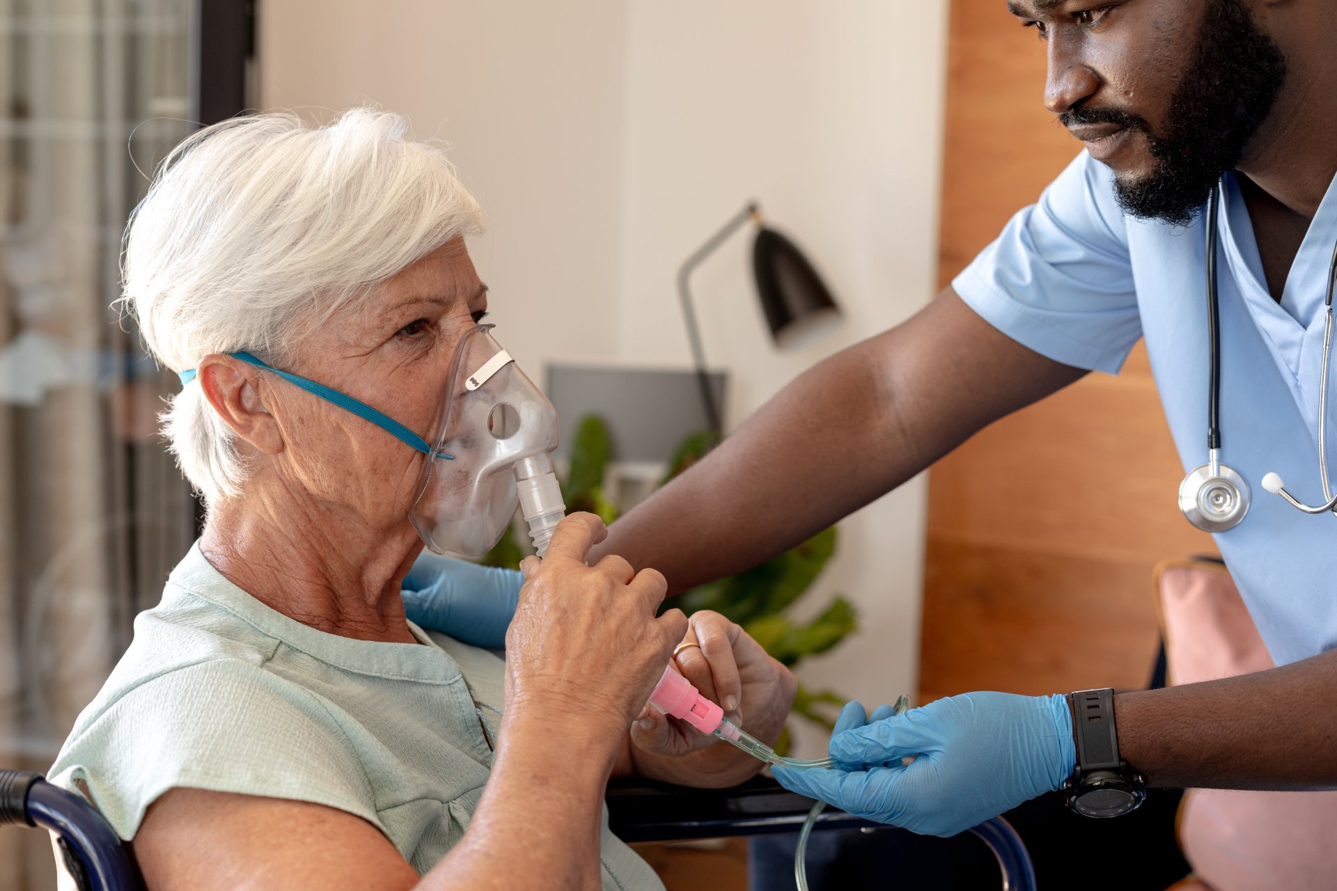 A respiratory therapist helps his patient use a breathing device. A respiratory therapist helps his patient use a breathing device.