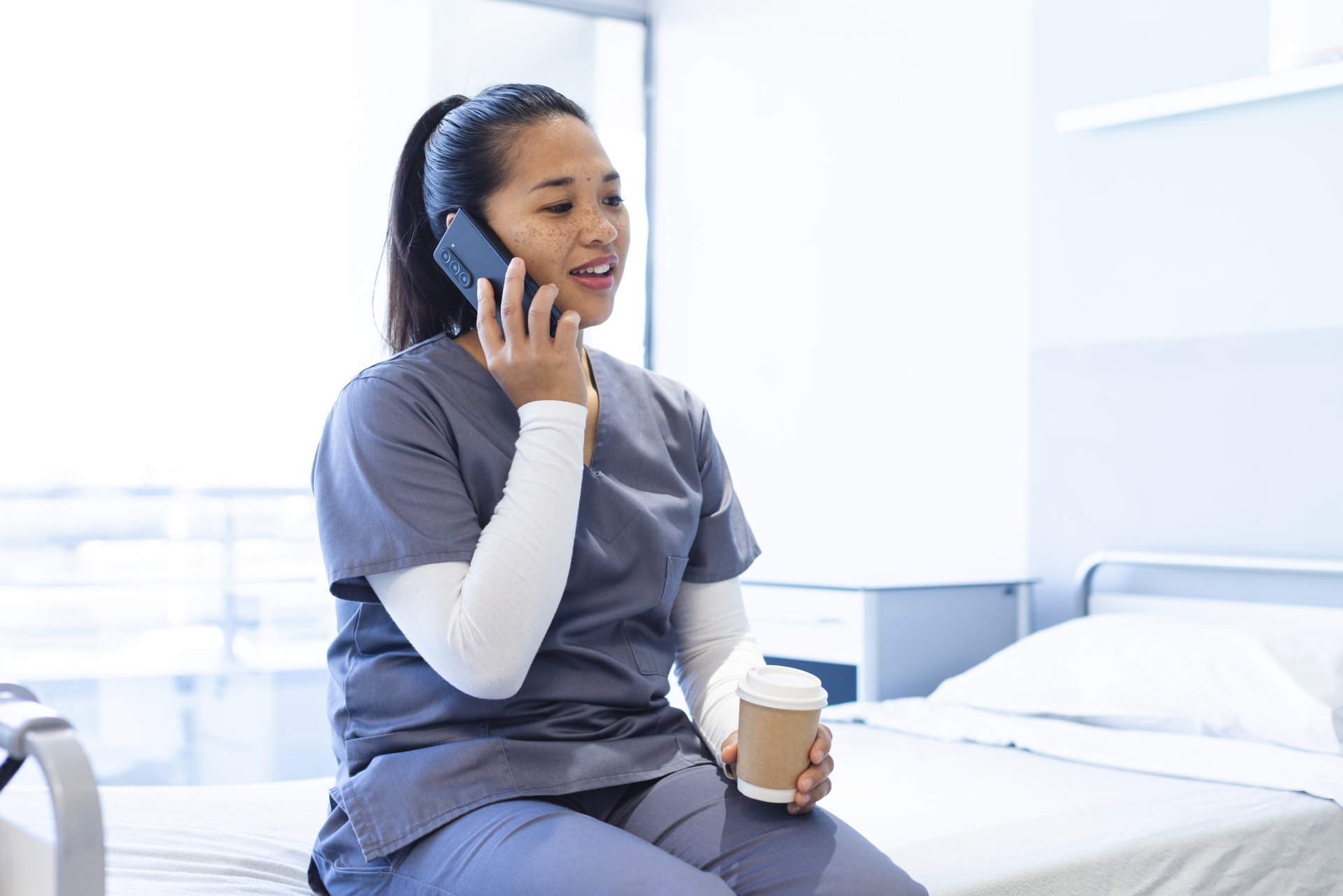 Healthcare worker holding coffee talking on the phone