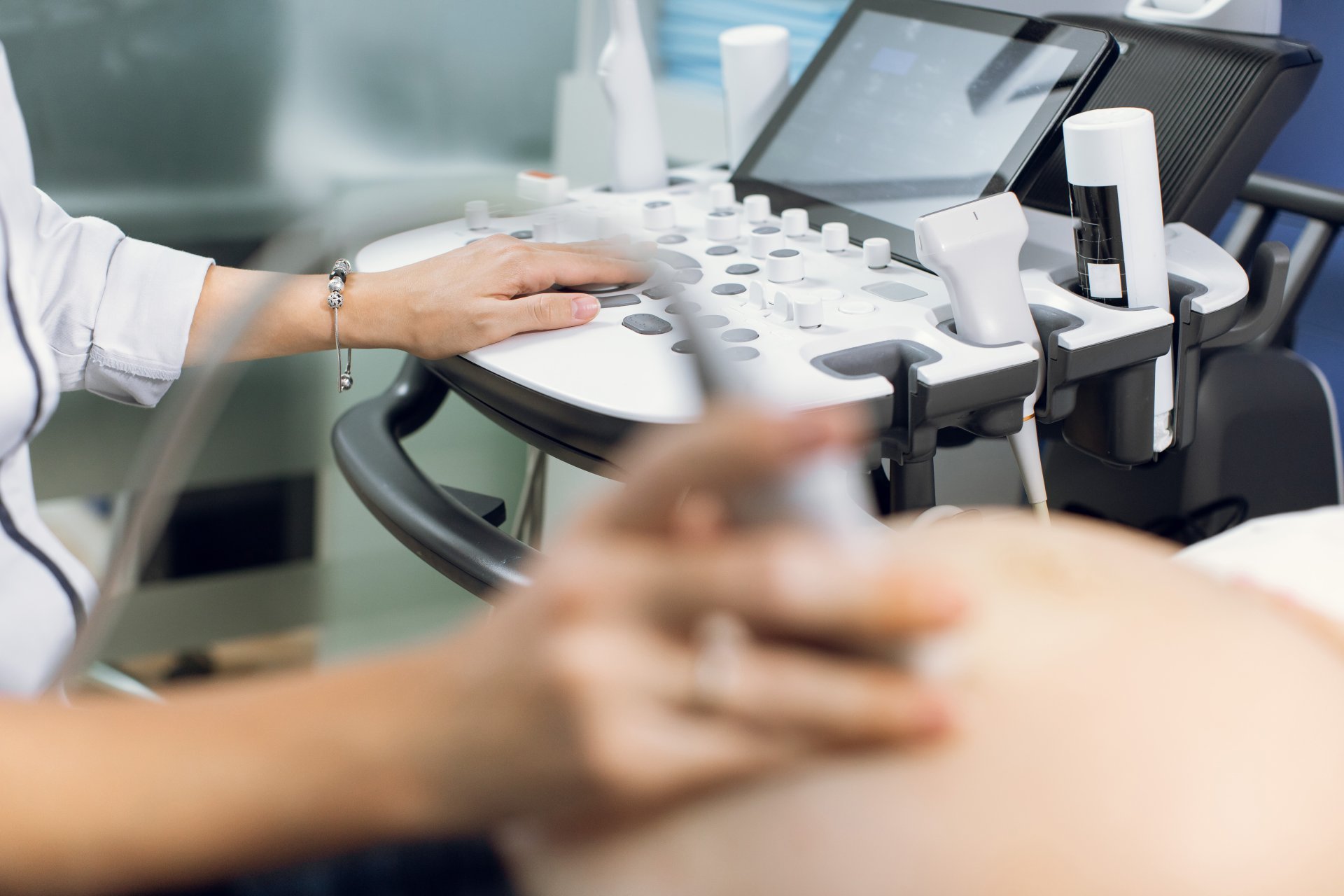 A sonographer observes the progress of a pregnancy using ultrasound.