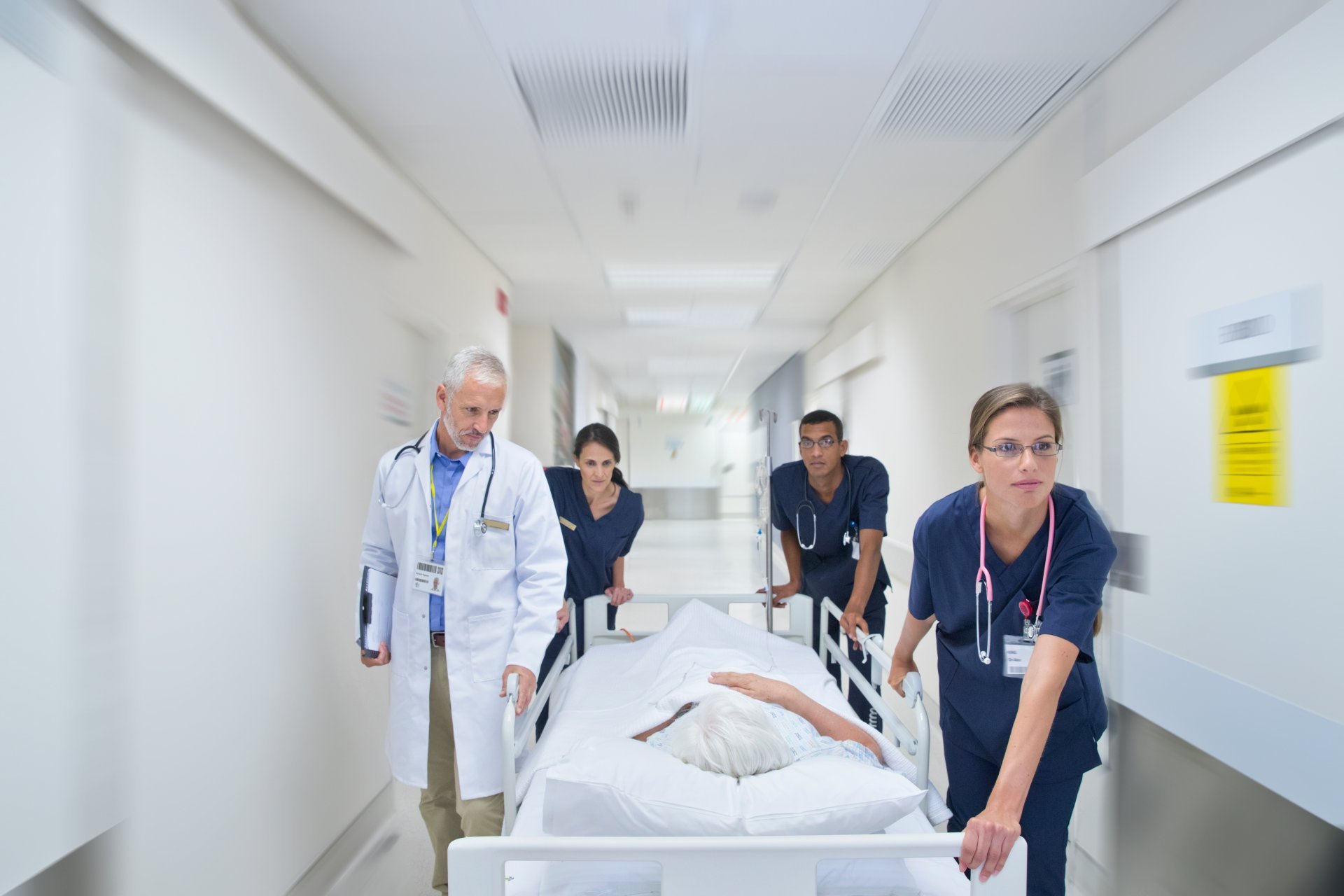 Emergency ER nurses wheeling patient down hallway