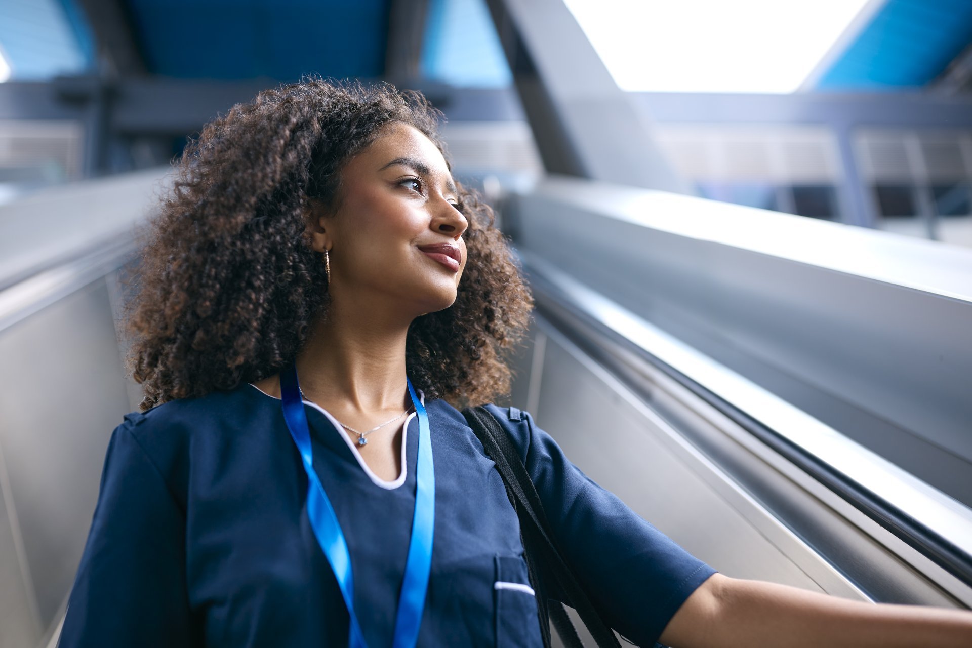 Female nurse commuting to work on an escalator