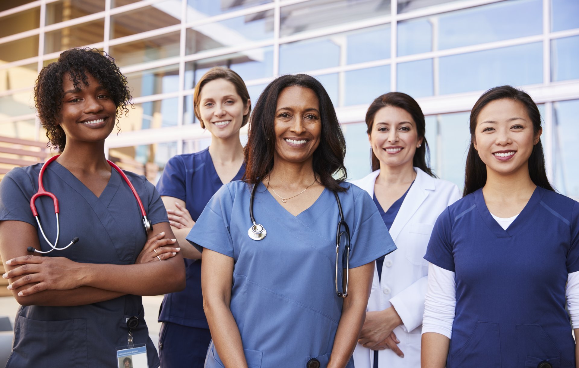 Healthcare team poses together outside hospital