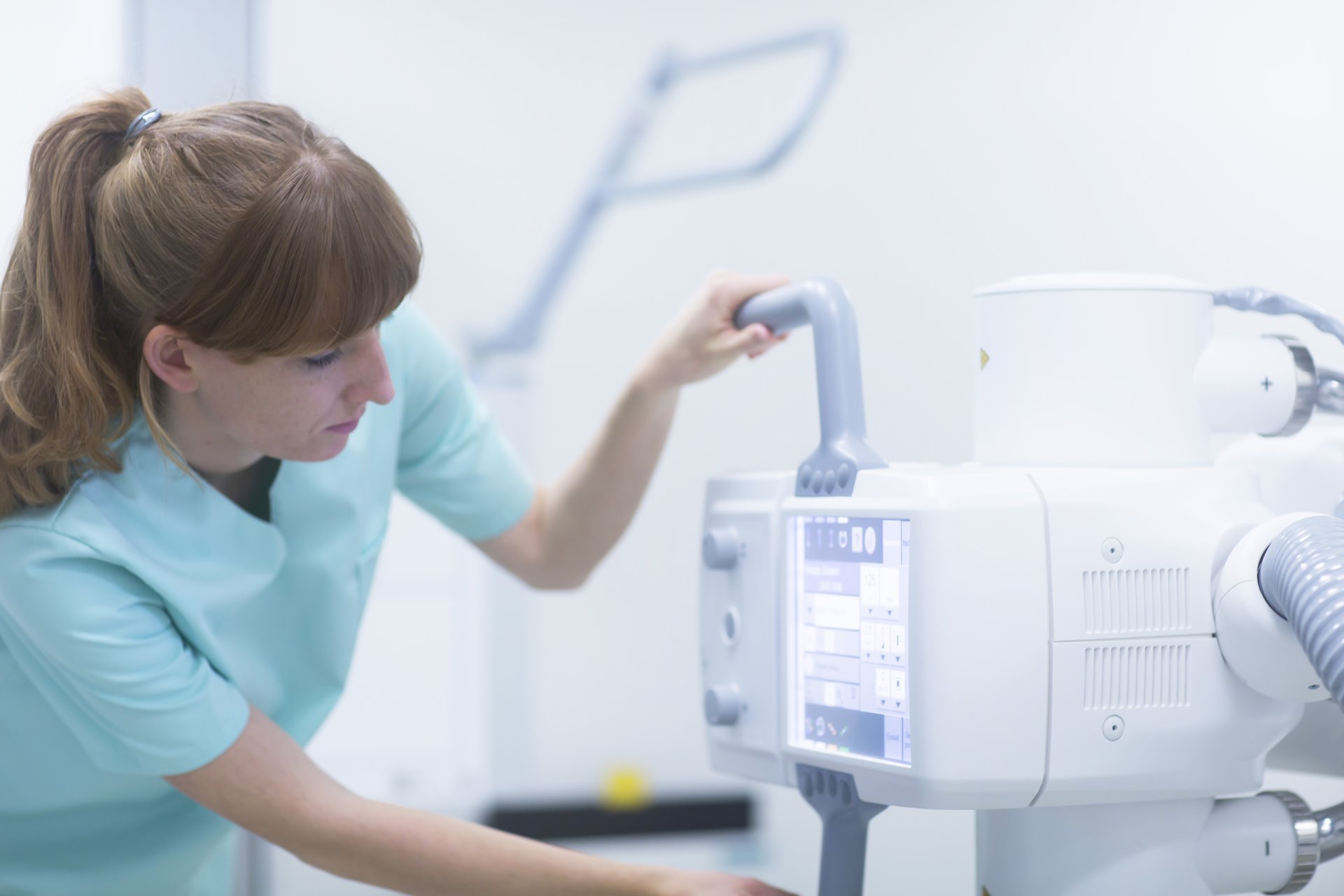 Female radiologist adjusting x-ray machine