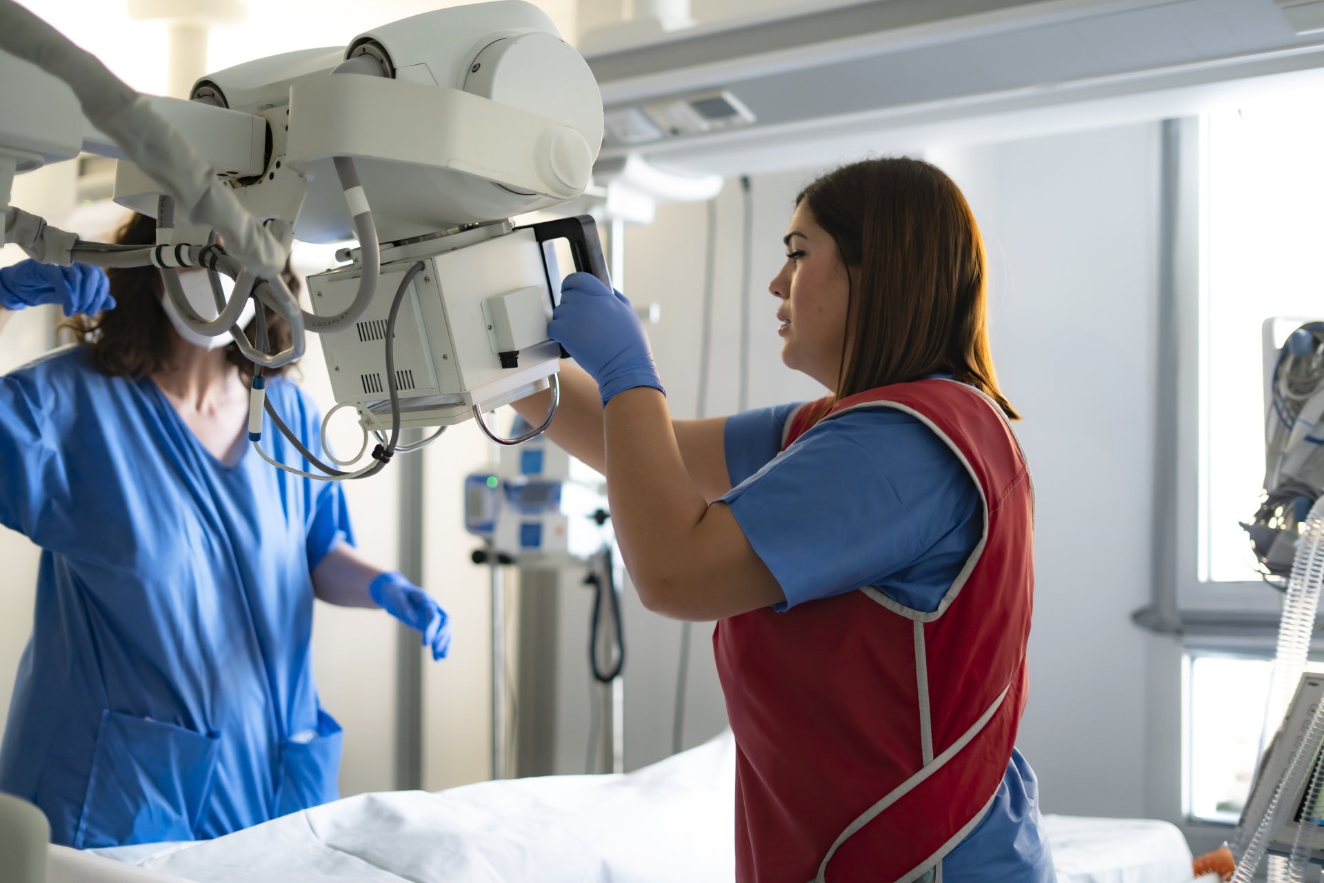Rad techs prepare an x-ray machine for the next patient