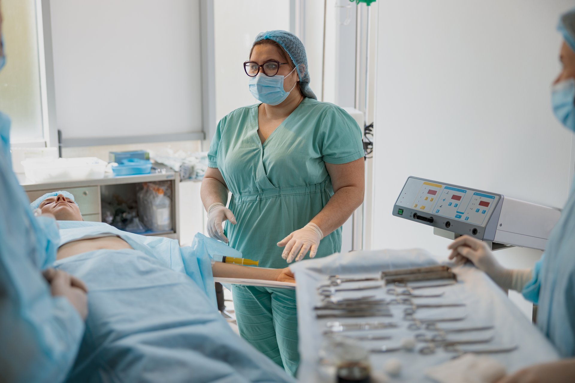 Nurse assisting doctors during surgery in operating room