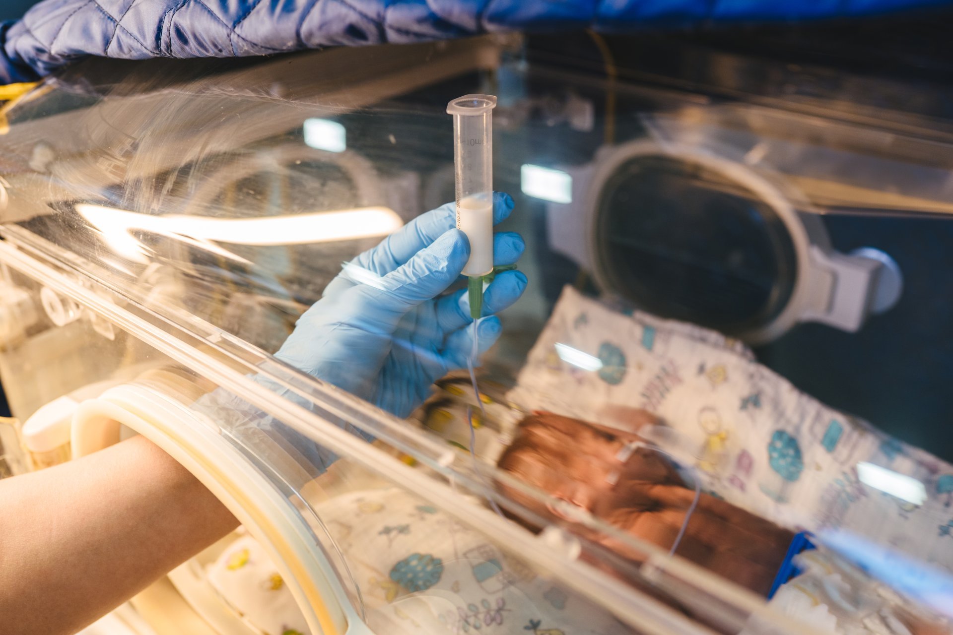 Nurse in neonatal intensive care unit carefully adds medicine to an IV Nurse in neonatal intensive care unit carefully adds medicine to an IV