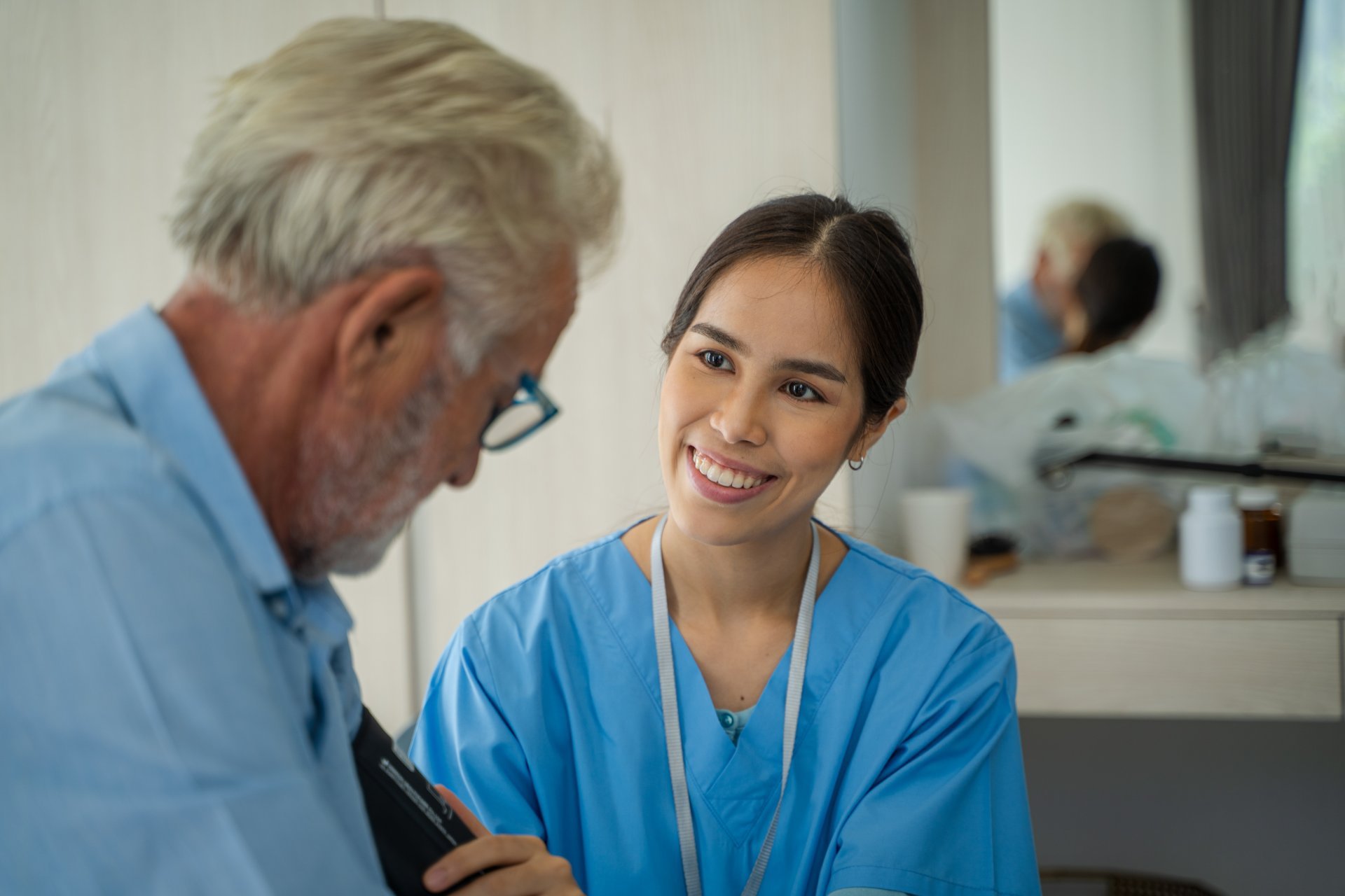 A nurse takes care of her senior male patient.