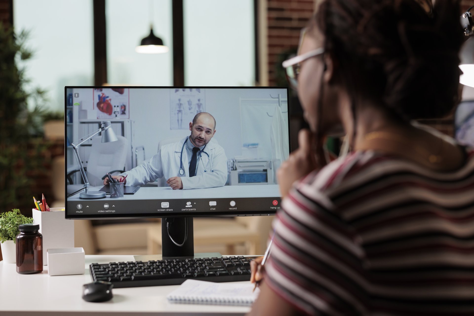 A patient speaks with her doctor via video call during a virtual appointment.