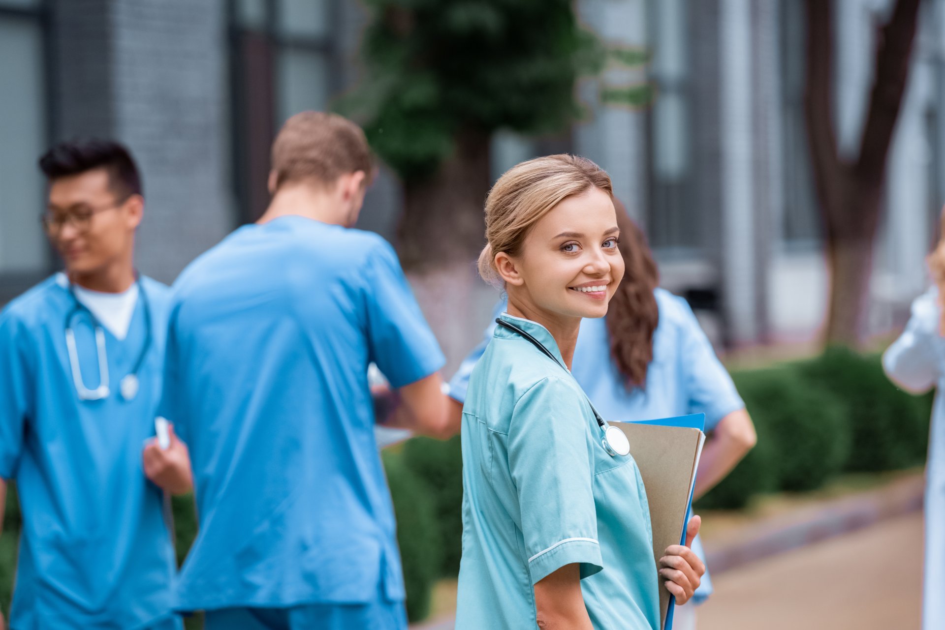 A smiling nursing student congregates with her classmates.