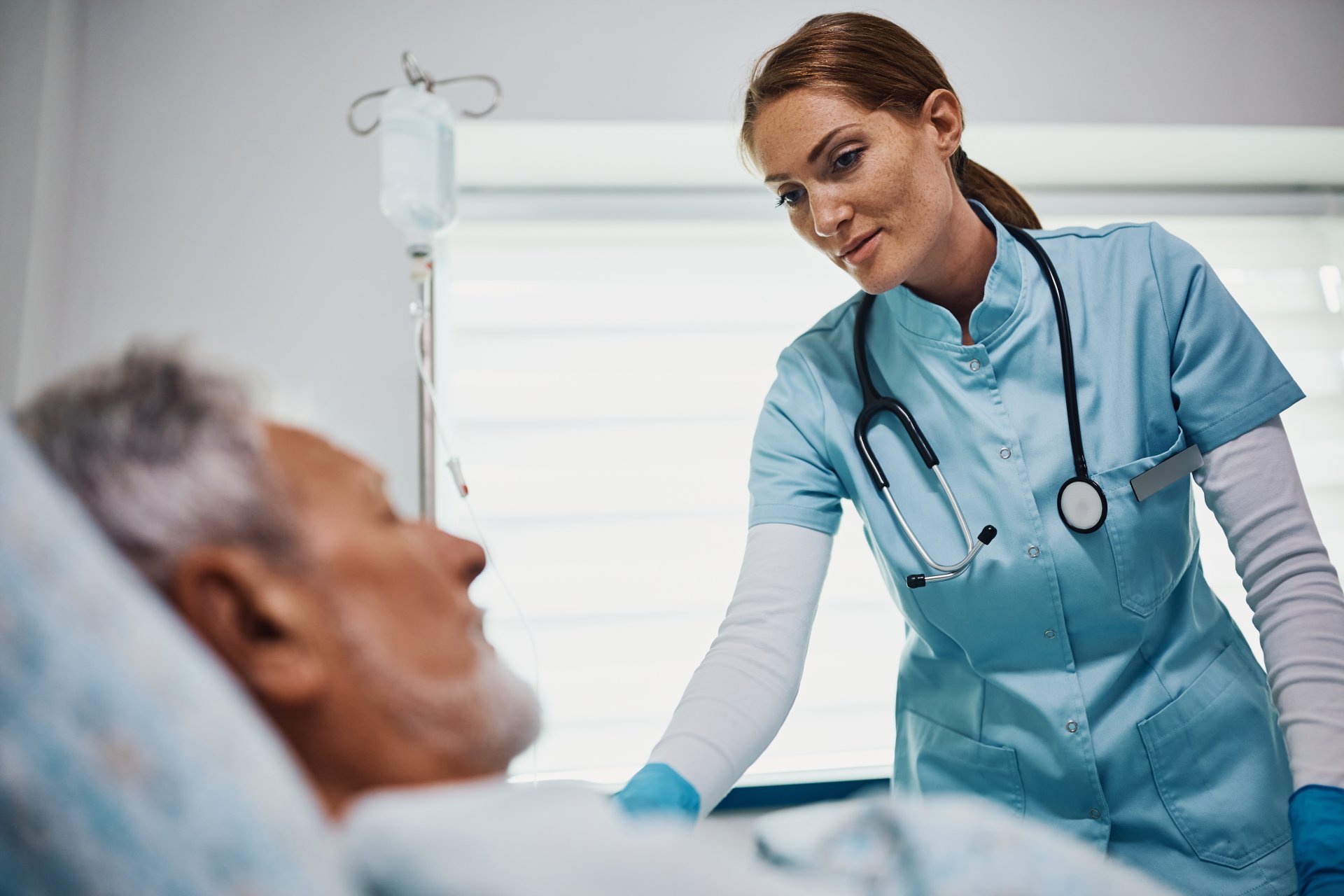 Smiling nurse checking senior patient at hospital