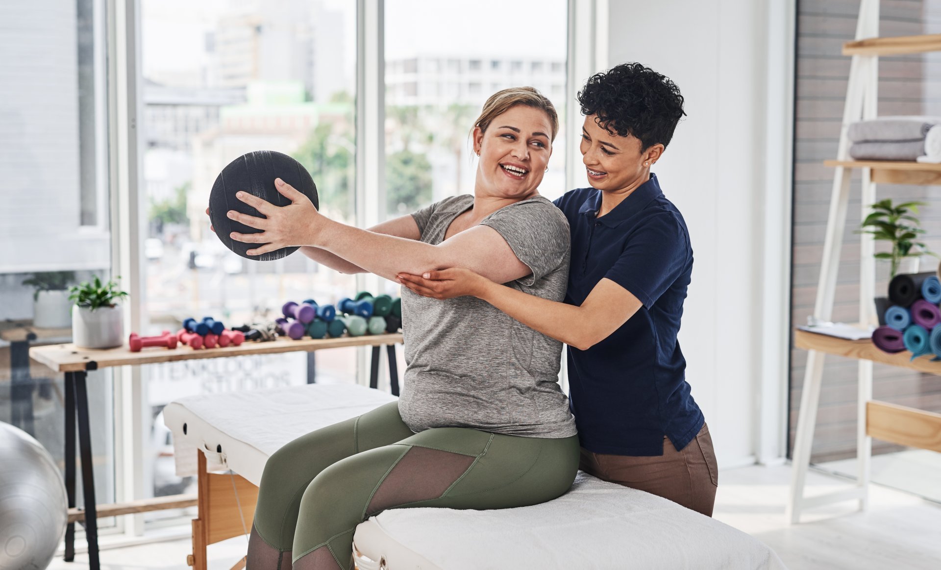 A physical therapist helps her patient with a medicine ball exercise. A physical therapist helps her patient with a medicine ball exercise.