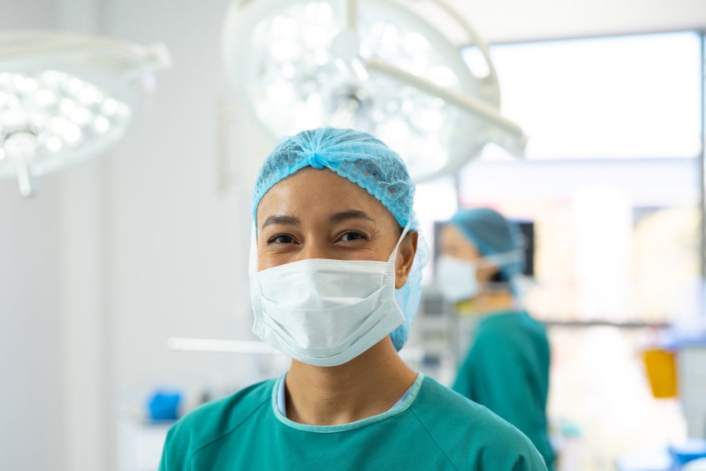 A nurse wearing scrubs and a mask